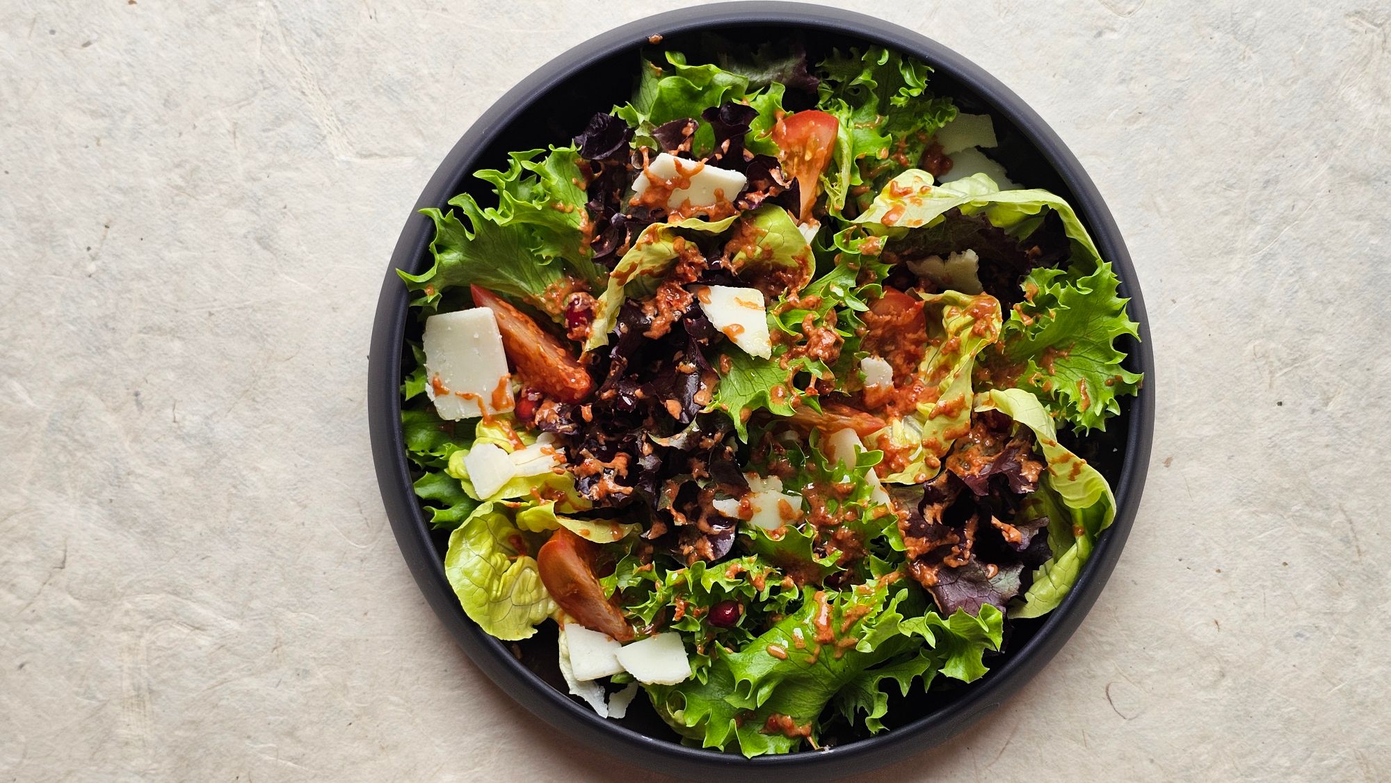 Frischer Blattsalat mit geriebenem gefrorenem Balsamico-Dressing in dunkler Schale